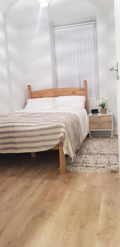 a bedroom with a bed and a wooden floor at Bowie's Abode in Sowerby Bridge