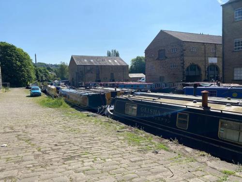 un groupe de bateaux est garé à côté d'un bâtiment dans l'établissement Bowie's Abode, à Sowerby Bridge