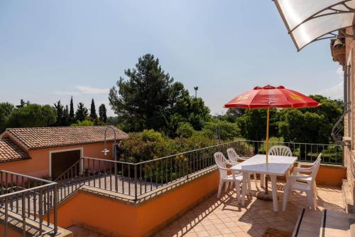 balkon ze stołem, krzesłami i parasolem w obiekcie Villa Martina w mieście Fano