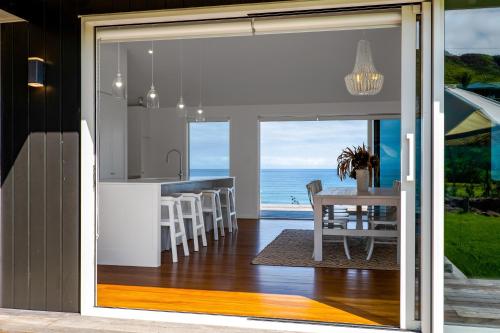een keuken en eetkamer met uitzicht op de oceaan bij MOKAU BEACH HOUSE in Mokau