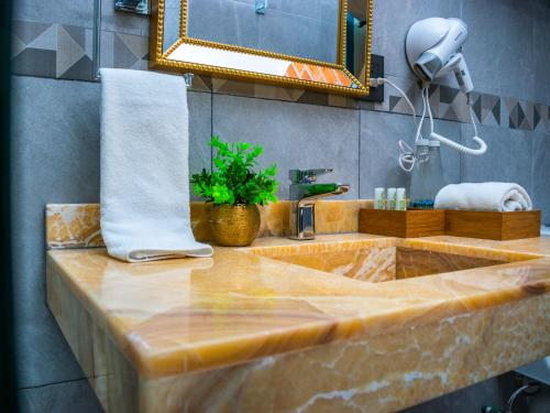 La salle de bains est pourvue d'un lavabo en marbre et d'un miroir. dans l'établissement HOTEL MARGARITA, à Puebla