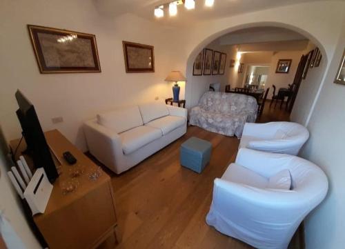 een woonkamer met een witte bank en een tafel bij Dimora Bellavista in Siena
