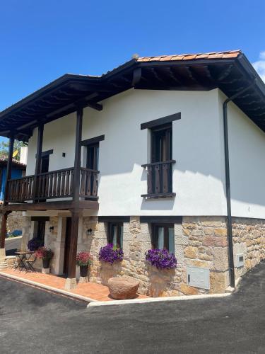 a white building with windows and a balcony at Casa Pepina in Pedroso