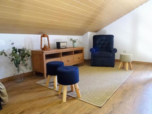 a living room with blue chairs and a desk at Casa das Andorinhas in Lourinhã