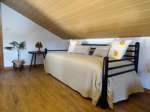 um quarto com uma cama grande e um tecto em madeira em Casa das Andorinhas na Lourinhã