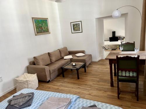 - un salon avec un canapé et une table dans l'établissement Apartment Georgstor im Posthalterhof mit Sauna, à Blankenheim
