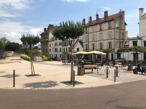 Un patio con mesas y sombrillas frente a un edificio. en Hyper centre Lagny/Marne, vue panoramique, en Lagny