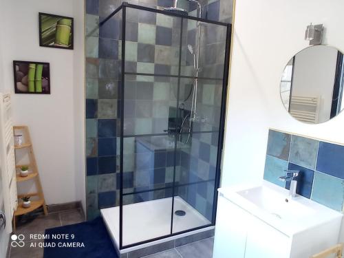 um chuveiro com uma porta de vidro ao lado de um lavatório em Vacances canal du midi em Ouveillan