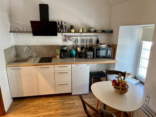 a kitchen with a table with a bowl of fruit on it at Apartment Georgstor im Posthalterhof mit Sauna in Blankenheim