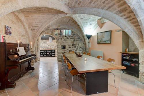 een grote eetkamer met een tafel en een piano bij Stunning Medieval Getaway in Vic-la-Gardiole