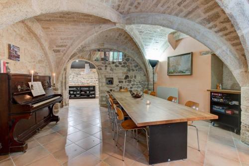 une grande salle à manger avec une table et un piano dans l'établissement Stunning Medieval Getaway, à Vic-la-Gardiole