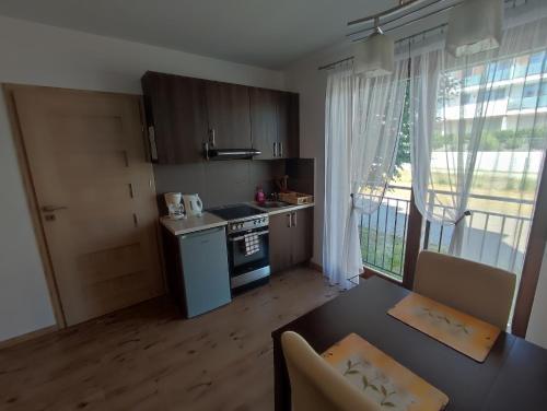 a kitchen with a table and a stove and a window at Apartament Posejdon in Sztutowo