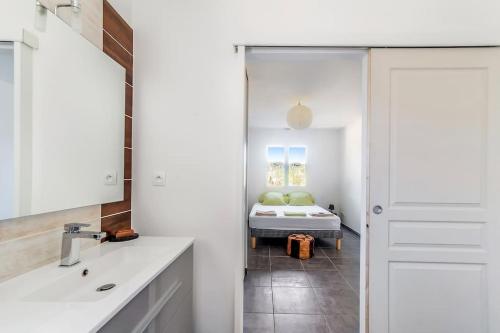 La salle de bains est pourvue d'un lavabo et d'un lit dans la chambre. dans l'établissement Le P'tit Gîte Gardéchois, piscine Ardèche - 12pers, à Saint-André-de-Cruzières