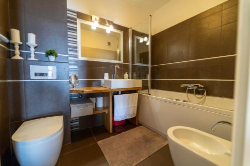 a bathroom with a sink and a toilet and a tub at Apartman Gratitude in Rijeka
