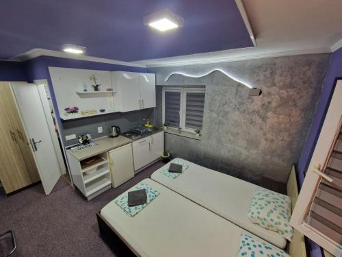 a small room with two beds and a kitchen at Rooms Vedran in Mostar
