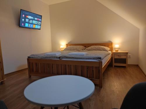 a bedroom with a bed and a tv on the wall at Apartmán Poštolka in Branná