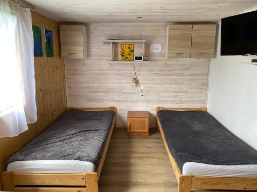 a room with two beds in a small room at Bieszczady Smolnik Cottage in Smolnik