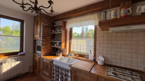 uma cozinha com um lavatório, um fogão e uma janela em Dom w sercu Kaszub em Parchowo