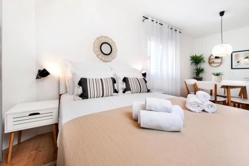 a white bedroom with a large bed and a chair at bed&breakfast Bohemian in Rovinj
