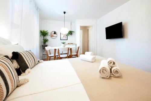 a white room with a bed and a dining room at bed&breakfast Bohemian in Rovinj