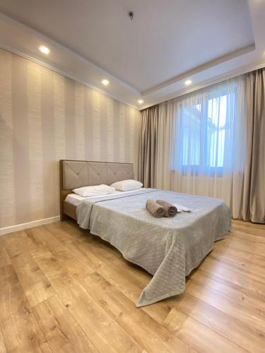 een slaapkamer met een bed en een groot raam bij Апарт Отель in Poti