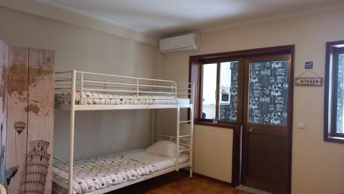 ヴィラ・ノヴァ・デ・ガイアにあるOporto Vasconcelos Guest Houseの二段ベッド2台とドアが備わる客室です。