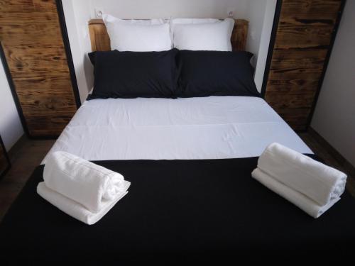 - un lit avec des draps blancs et 2 oreillers dans l'établissement L'atelier, à Foissac