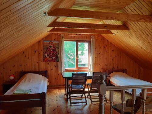 Zimmer mit 2 Betten und einem Tisch in einer Hütte in der Unterkunft Brīvdienu māja Ievkalni in Jūrkalne