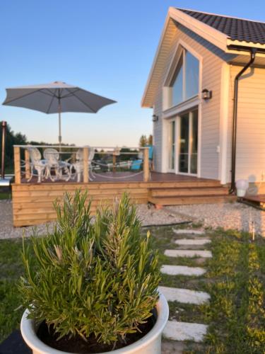 a patio with an umbrella and some plants in a yard at Relax House By The Stone in Nugariai