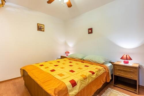 a bedroom with a bed and a night stand with two lamps at Kovacine apartment in Cres