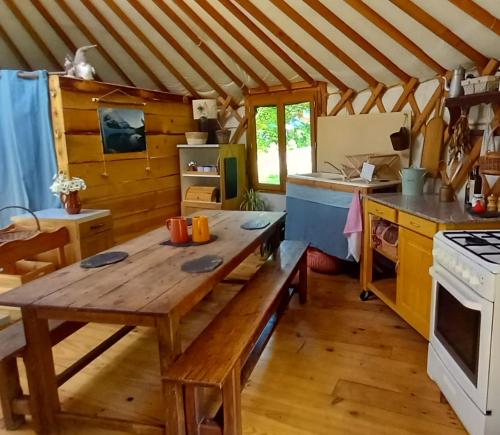 a kitchen with a wooden table in a room at Yourte Immersion Nature in Saint-Étienne-de-Chomeil