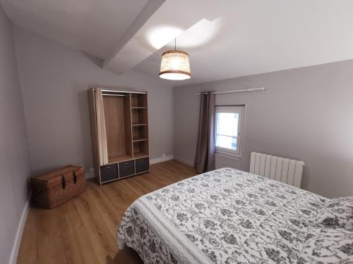 ein Schlafzimmer mit einem Bett, einer Kommode und einem Fenster in der Unterkunft Appartement centre ville, parking gratuit in La Rochefoucauld