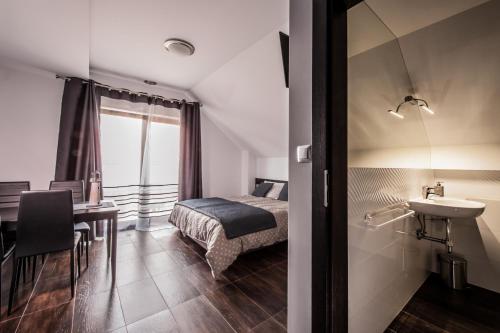 um quarto com uma cama, um lavatório e uma mesa em Rezerwat85 em Gdansk