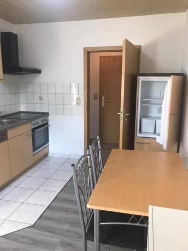a kitchen with a table and chairs and a refrigerator at Fewo 71 Kleine 1 Raumwohnung in Roggow in Roggow
