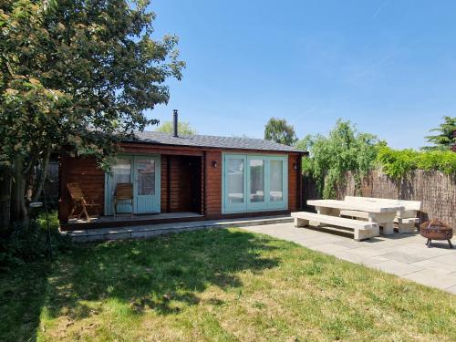a log cabin with a picnic table and a patio at Caban Cwtch - Log fire, pool table, hot tub cinema in Kent