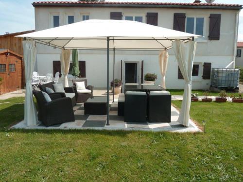 a white gazebo with couches and chairs in a yard at Gite Au Cheval D'or in La Meilleraie-Tillay