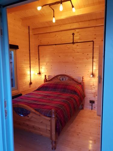a bedroom with a bed in a log cabin at Caban Cwtch - Log fire, pool table, hot tub cinema in Kent