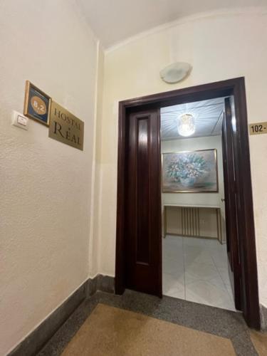 un couloir avec une porte marron dans un bâtiment dans l'établissement Hostal Real, à Vigo