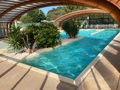 - une piscine d'eau bleue dans un complexe dans l'établissement Chalet rénové, environnement très calme, piscines intérieure et extérieure chauffées, Bord du lac de Biscarosse Parentis, à Parentis-en-Born