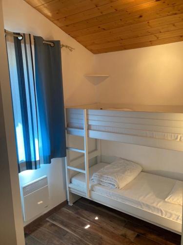 une chambre avec deux lits superposés et une fenêtre dans l'établissement Chalet rénové, environnement très calme, piscines intérieure et extérieure chauffées, Bord du lac de Biscarosse Parentis, à Parentis-en-Born