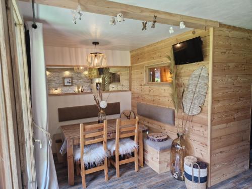 une salle à manger avec une table, des chaises et une télévision dans l'établissement Belle-Plagne / Cœur de station / Ski aux pieds, à Belle Plagne