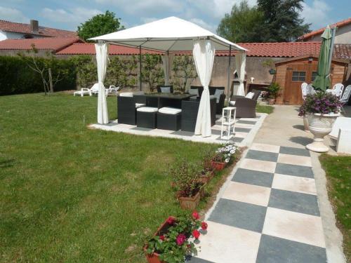 a gazebo in a backyard with a checkeredkered sidx sidx at Gite Au Cheval D'or in La Meilleraie-Tillay