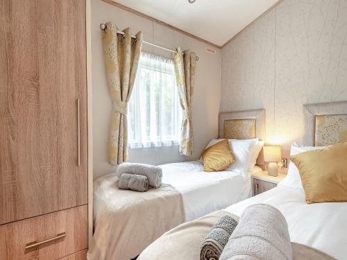 a bedroom with two beds and a window at Tradmach Lodge in Patrington