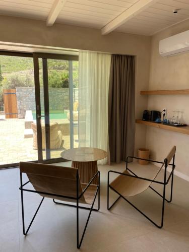 uma sala de estar com duas cadeiras e uma mesa em Melitsina Village Hotel em Kardamili