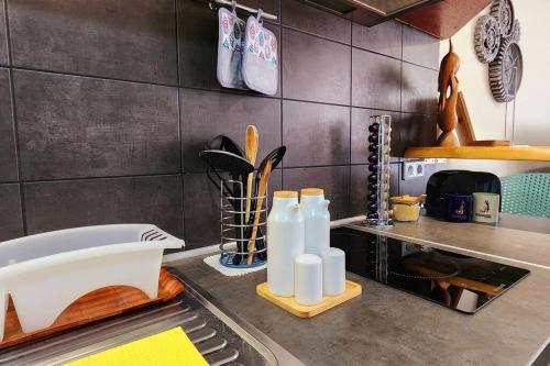 a kitchen counter with a sink with bottles on it at Chez Eden Coconut Studio in Papeete