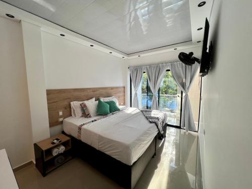 ein Schlafzimmer mit einem Bett und einem großen Fenster in der Unterkunft HOTEL TORRE DELUXE ¨SANTORINI¨ in Doradal