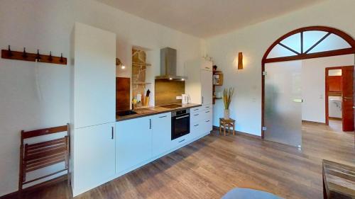 a large kitchen with white cabinets and a wooden floor at Las Fincas Baabe in Baabe