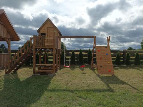 a playground with a slide and a play structure at Przytulisko na Mazurach in Ruciane-Nida