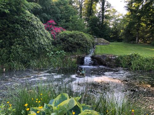 a pond in the middle of a garden with a waterfall at 300m2 entire house with 3 bedrooms in Tistrup