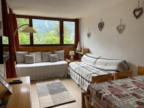 - un salon avec deux lits et une fenêtre dans l'établissement Casa i Larici del Brenta, à Folgarida